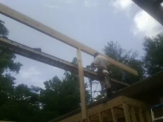 Carpenter setting a ridge beam over a new addition frame — Ice Dam Removal by Roofing Brothers in Keedysville