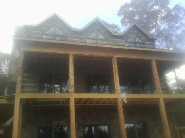 Dormers and porch framing on a large log home under construction — Roof Coating work by our crew in Keedysville